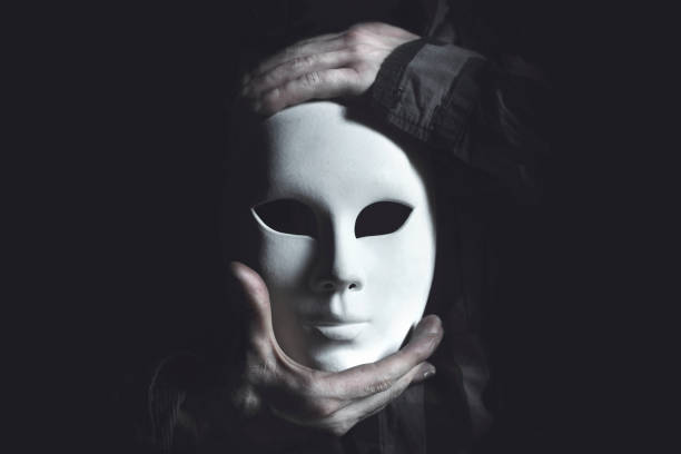 mains tenant le masque blanc - masque de la commedia dellarte photos et images de collection