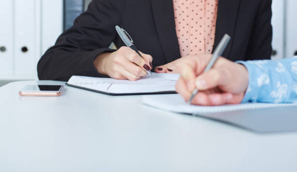 istock Business man making notes at office workplace with his female colleague on the background. Business job offer, financial success, certified public accountant concept. 861868732