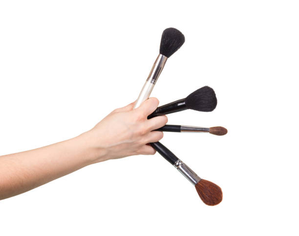 istock Four cosmetic brushes in female hand isolated on white background. 861868950