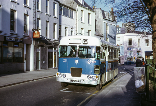Vintage image of bus waiting at a bus stop in St Helier, Jersey.  Jersey Motor Transport Bedford VAS  676 (registration J 36676).
