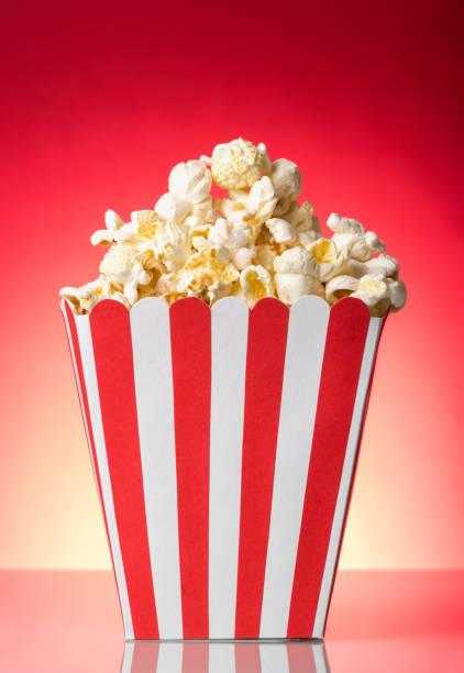 istock Salty popcorn in large square box on bright red. 861873904