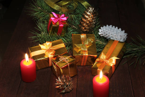 istock Christmas gift colored boxes, cones, Christmas tree and candles on a wooden table. Composition of celebrities. Selective focus. 861877036