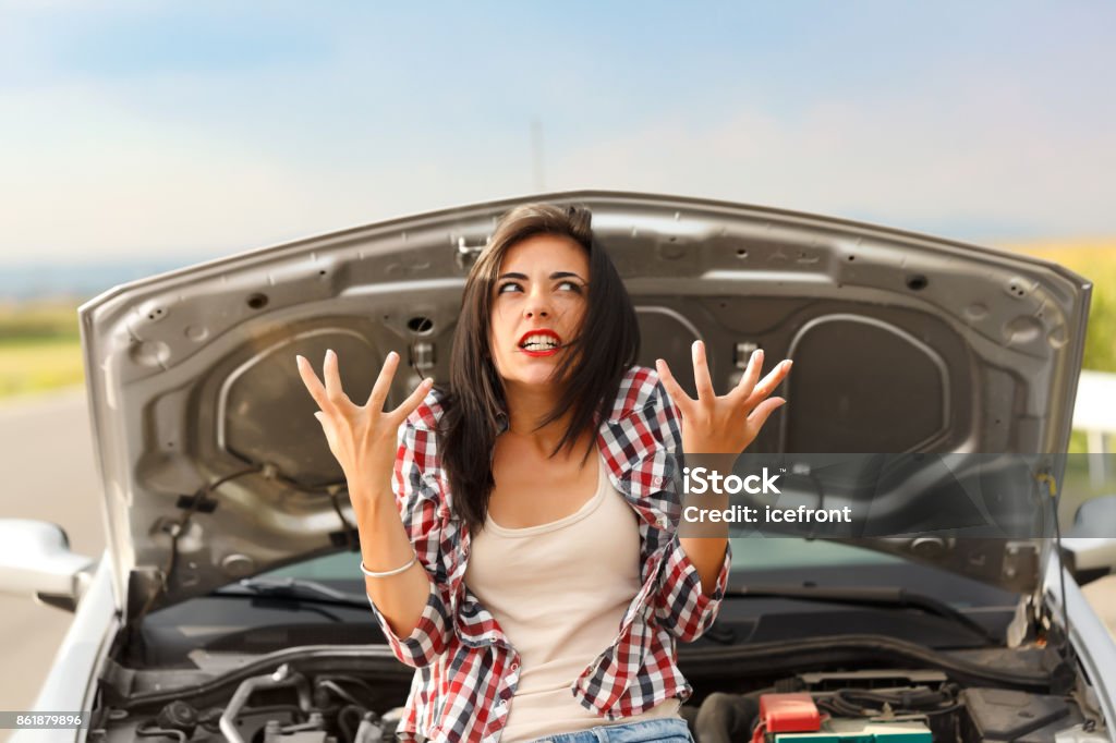 Madness due to broken car Woman being very angry because of her car's failed engine Vehicle Breakdown Stock Photo