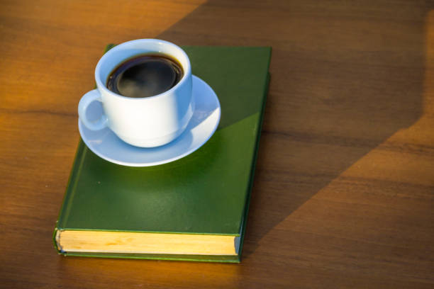 istock Cup of coffee and book on wooden table 861884126