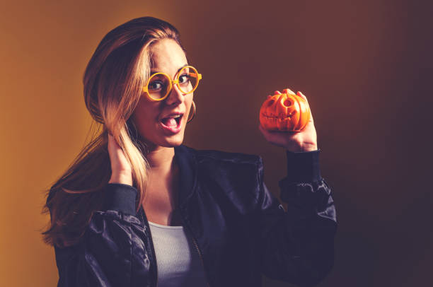 giovane donna che tiene in mano una zucca - pumpkin small orange holiday foto e immagini stock