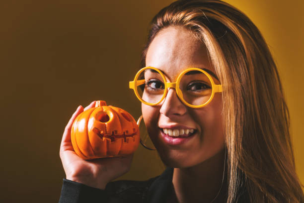 giovane donna che tiene in mano una zucca - pumpkin small orange holiday foto e immagini stock