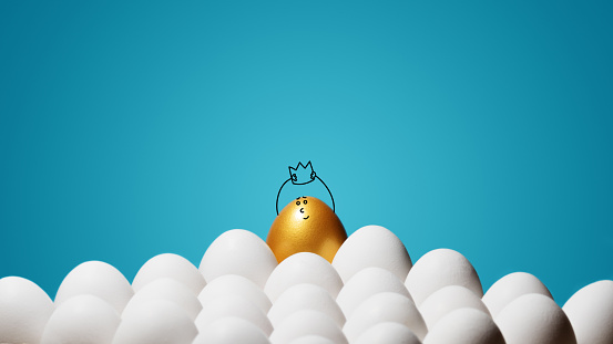 Concept of individuality, exclusivity, better choice, winning and ambition. A smiling golden egg with funny drawn face and with a crown among white eggs on blue background.