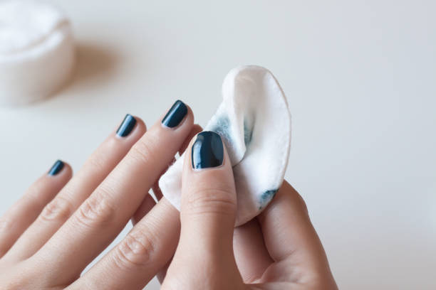 Woman removes the nail polish. Dark blue manicure. stock photo