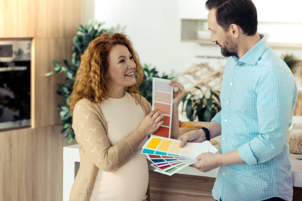 istock Cheerful wife holding papers with colors 861902590