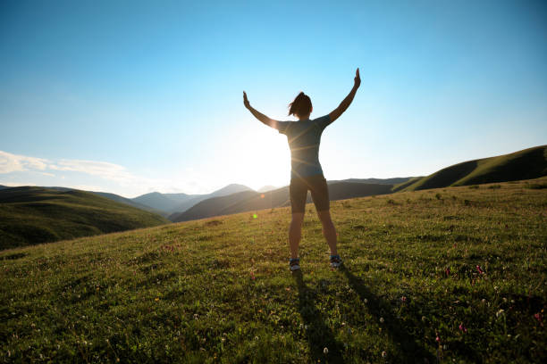 istock cheering woman open arms to sunset at mountain top 861903936