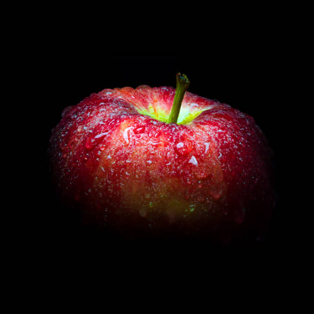 istock Water droplet on glossy surface of red apple on black background 861904440