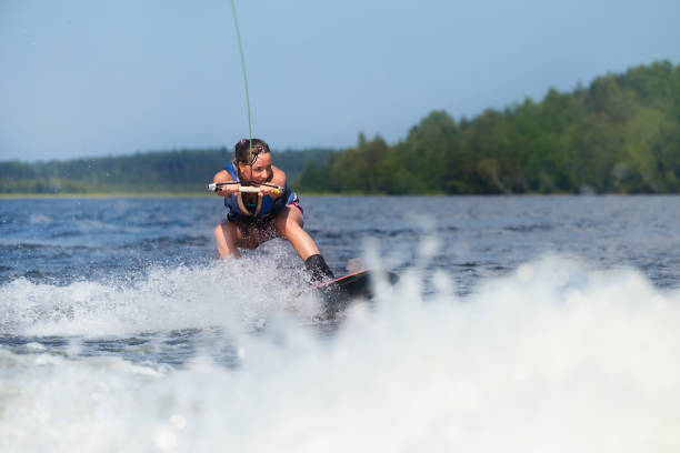 istock woman riding wakeboard on motorboat wave in lake 861904724