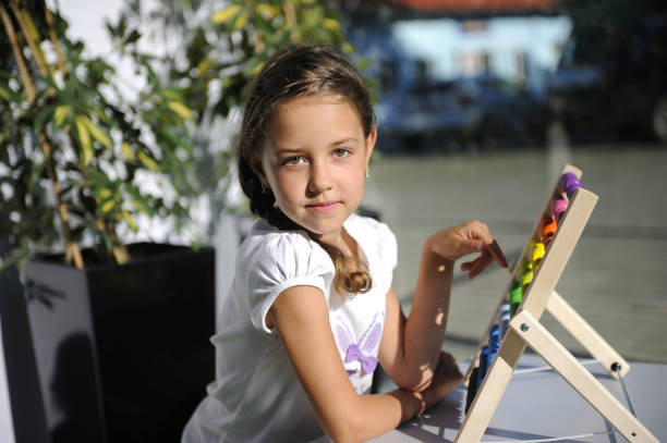 istock Eight-year-old girl learns to count and play 1 861911394