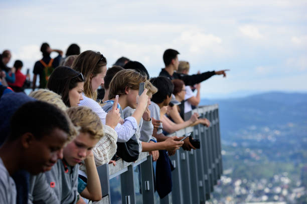 Crowd enjoying the view from top of Mount Fløyen. Bergen city Bergen, Norway - August 9, 2017: Crowd enjoying the view from top of Mount Fløyen. Taking pictures. Watching Bergen city. fløyen stock pictures, royalty-free photos & images