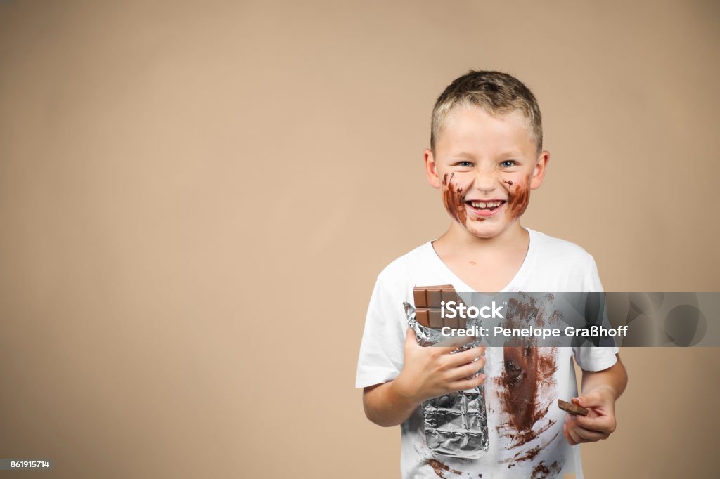 Petit garçon tient une tablette de chocolat à la main - Photo de Chocolat libre de droits