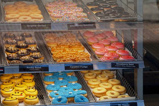 Variety of donuts in a display case of a bakery in Amsterdam.