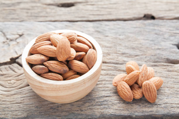 istock group of almonds  from wood bowl on wood background 861931842