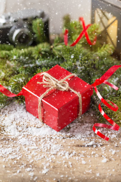 istock Red present box candle and retro camera with snow Christmas composition 861932084