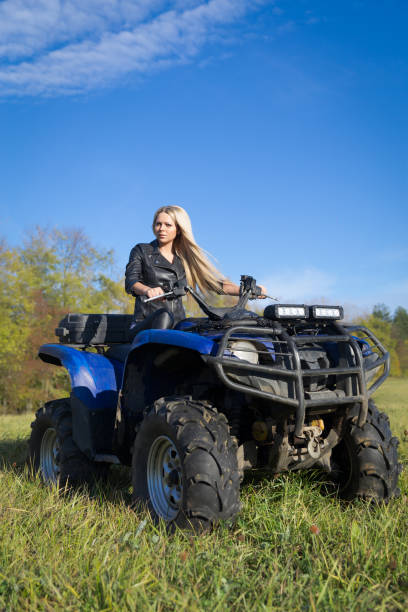 istock Young blonde woman riding ATV on a field 861934546