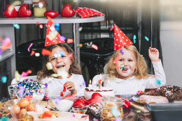 dos pequeñas niñas niño feliz celebrando un cumpleaños con torta en la mesa es preciosa y hermosa - cake birthday domestic kitchen child fotografías e imágenes de stock