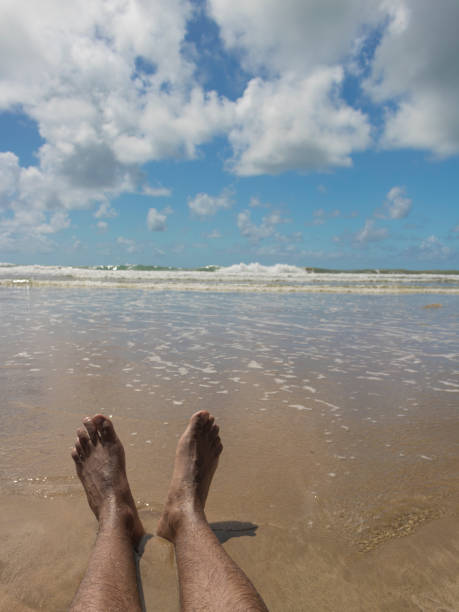 istock Male feet on sand with seashells 861969846