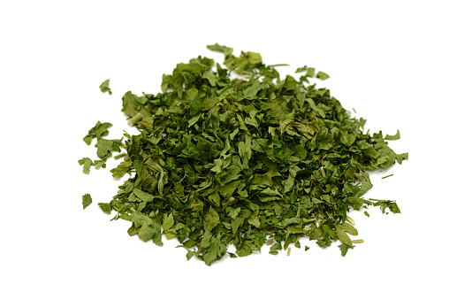 pile of green dried parsley on a white background