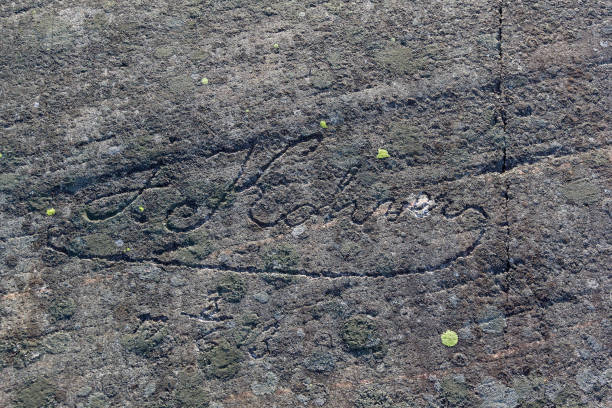 Old half-erased inscriptions, embossed on a granite rock.