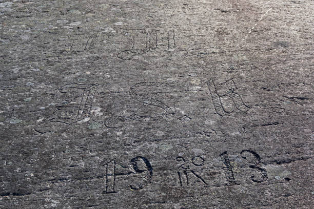 Old half-erased inscriptions, embossed on a granite rock.