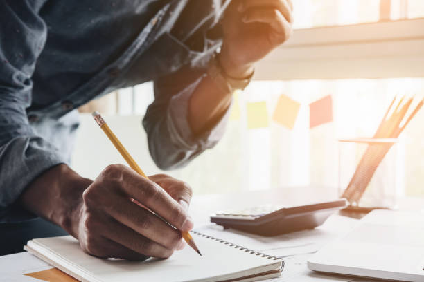 istock Close up accountant man using calculator while writing make note about cost profit at home office. 861975784