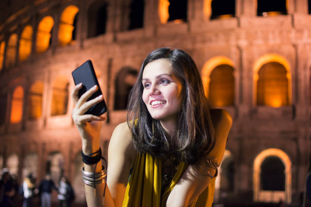 istock Smiling young woman using phone in Rome, Italy 861978528