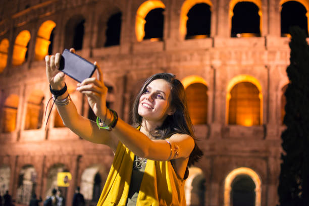 istock Smiling young woman using phone in Rome, Italy 861978546