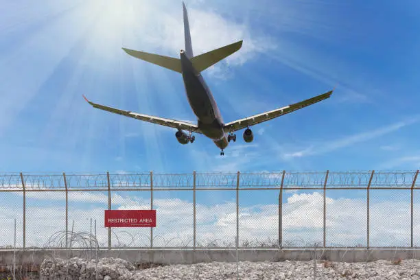 Restricted area fence and Passenger airplane landing beautiful blue sky background