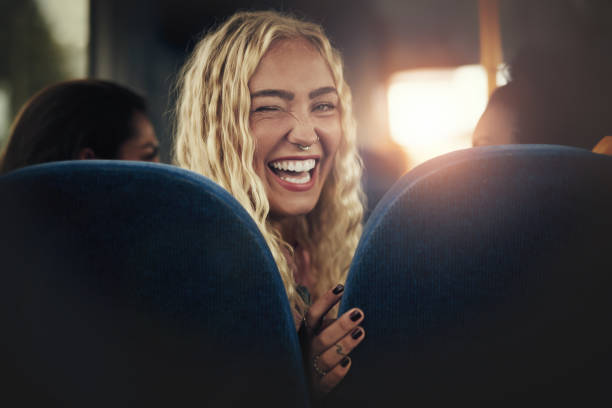 若い女性の笑いとバスに座ってウインク - metro bus ストックフォトと画像