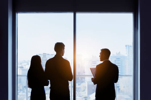 Couple and real estate agent window deal concept Couple and real estate agent stands near window and speaks before signing contract. Business concept estate worker stock pictures, royalty-free photos & images