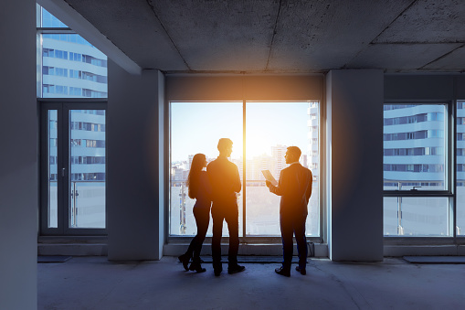 Real estate concept with agent and couple near big panoramic window