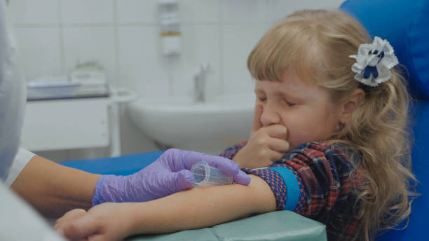 ナースは少女の腕の静脈から血液サンプルを取っています。 - little girls vaccination child caucasian ストックフォトと画像