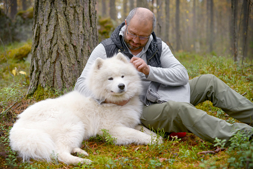 Mature Adult man with a white dog outdoors