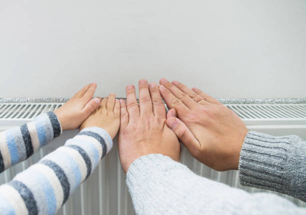 istock Father and son warming hands on the heating radiator 861988164