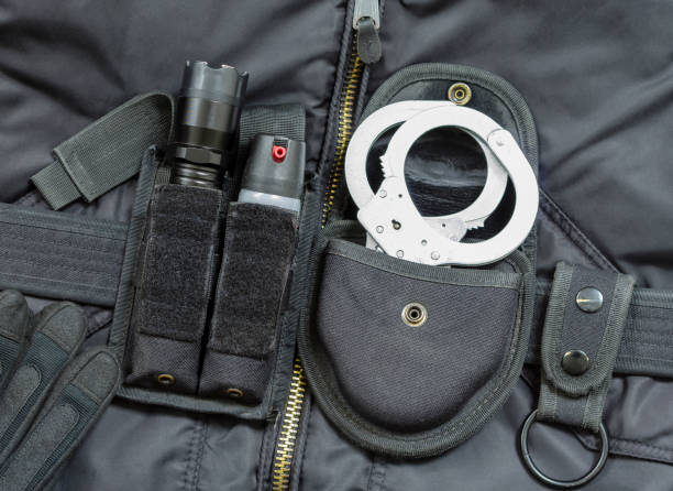 Part of Police officer equipment. Tear gas spray, flashlight with stun gun, handcuffs. Part of Police officer equipment. Tear gas spray, flashlight with stun gun, handcuffs. tear gas stock pictures, royalty-free photos & images