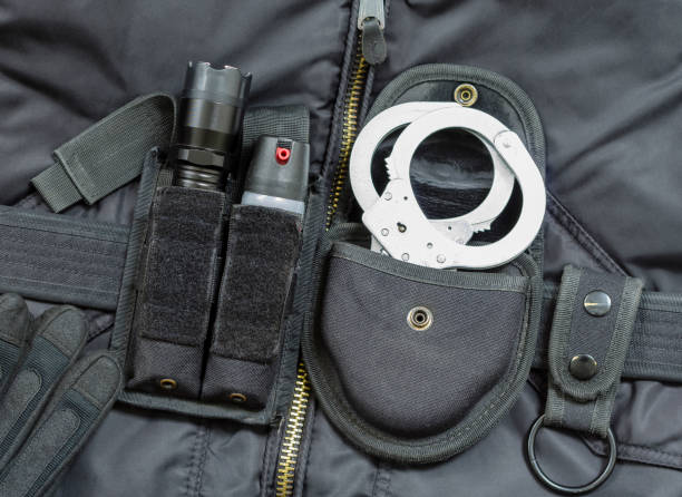 Part of Police officer equipment. Tear gas spray, flashlight with stun gun, handcuffs. Part of Police officer equipment. Tear gas spray, flashlight with stun gun, handcuffs. police tear gas stock pictures, royalty-free photos & images