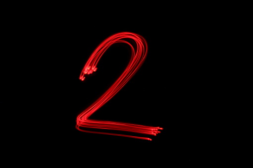 a red number, light painting, on a clean, black background