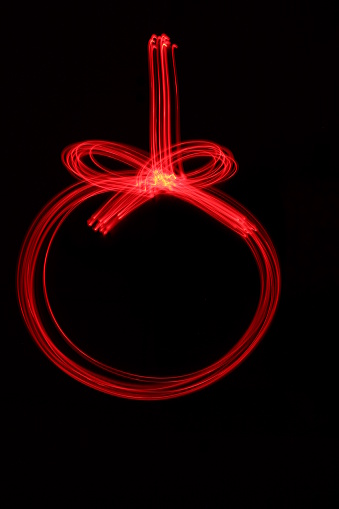 red light painting bauble ornament shape, against a black background