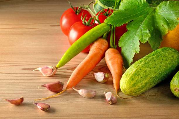istock Cucumbers, tomatoes, carrots, garlic, zucchini on wooden table. 862010044