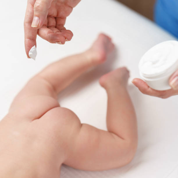 istock mom applying some cream by her hand to the babby ass 862010472