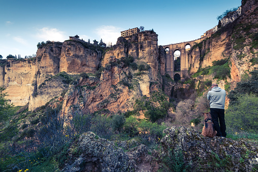 Travellers man and dog looking at Ronda city in Spain.