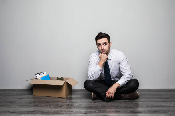 istock Fired sad man in suit sitting on floor in office 862021692