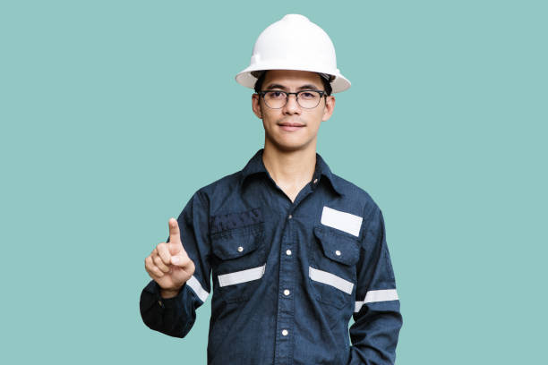 Asian man,Engineer or Technician in white helmet, glasses and blue working shirt suit Pointing the finger, isolated on white, mechanic and Oil and Gas industrial concept with clipping path.