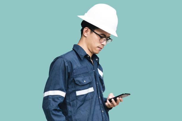 istock Asian man,Engineer or Technician in white helmet, glasses and blue working shirt suit using smart phone, isolated on green, mechanic and Oil and Gas industrial concept with clipping path. 862023234