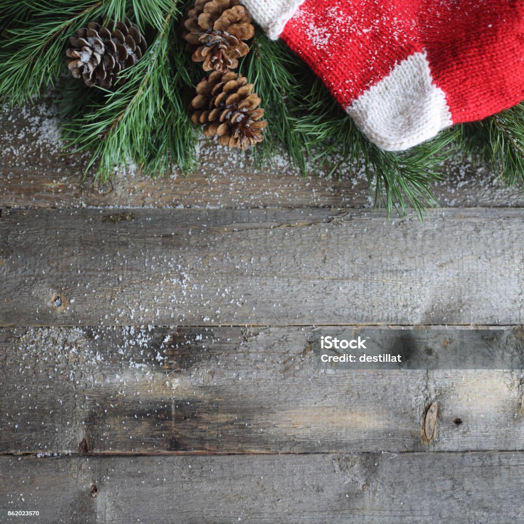 Christmas card on wooden background Christmas card on wooden background with snow and fir tree branch with pine cones and christmas gift sock. View with copy space Backgrounds Stock Photo