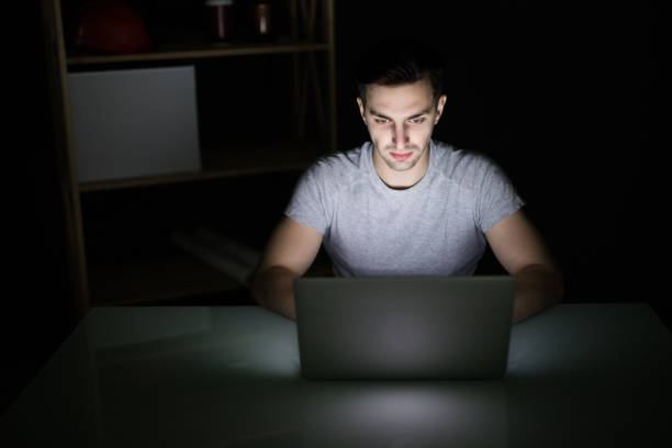 istock Architect sitting at night working on architectural plan on laptop. Young interior designer in casual checking blueprint of a house on laptop. Architect studying the map and layout of a new project. 862026520